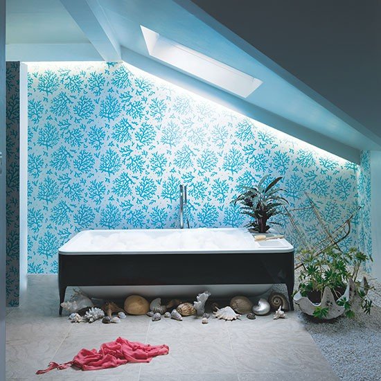 Banheiro com papel de parede azul e conchas