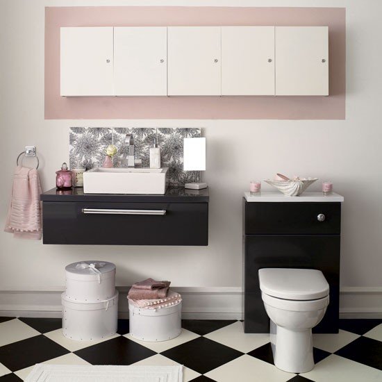 Banheiro com piso xadrez preto e branco e detalhes rosa