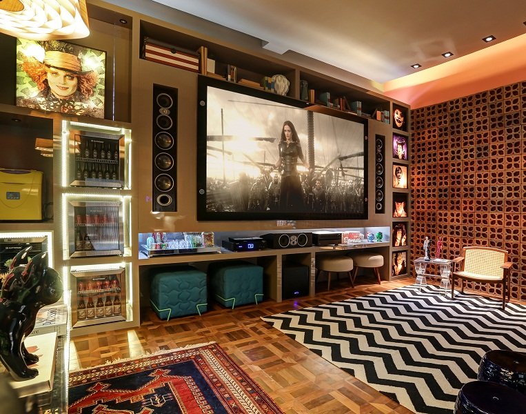 Home theater com revestimento de cobogó e paredes verde-escuras