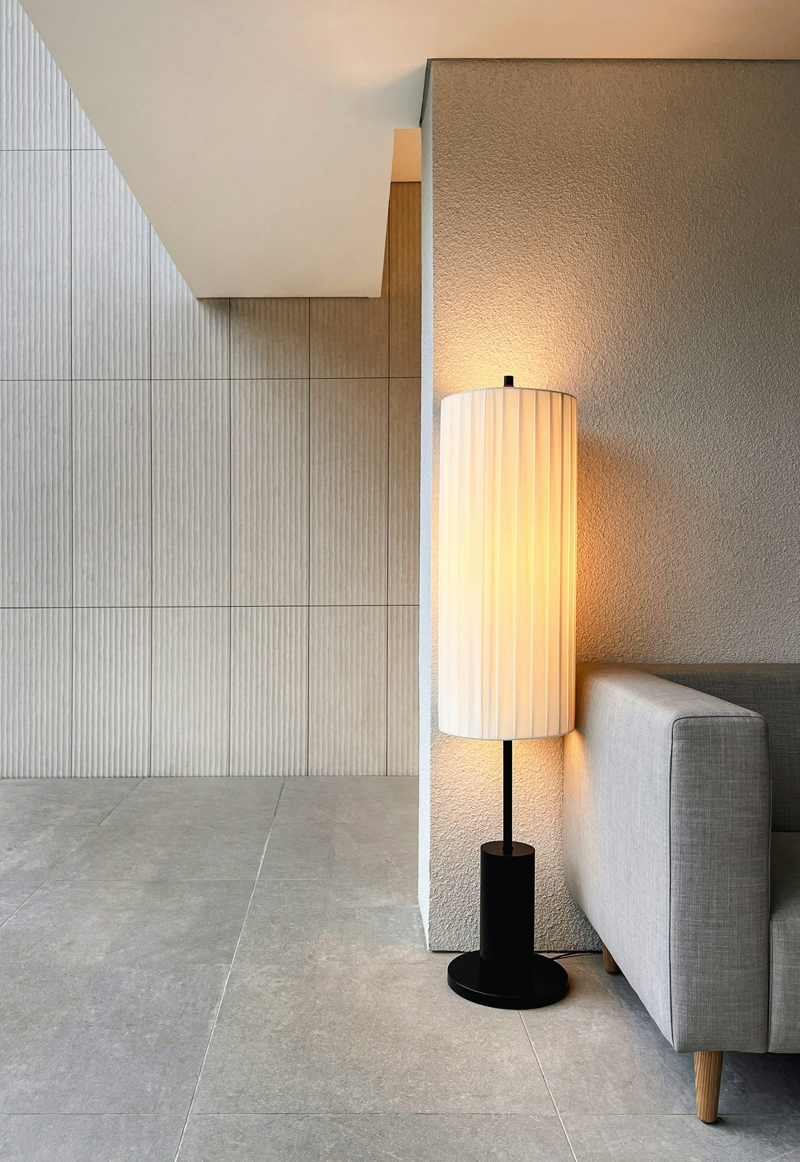 Luminária de piso acesa junto ao sofá