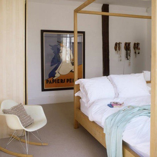 Quarto neutro com cama de madeira no centro