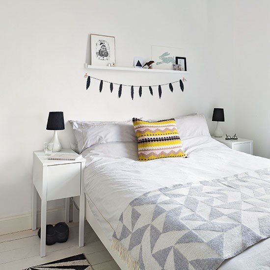 Quarto todo branco com manta e almofada