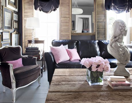 Sala pequena com paredes cor de carvão e almofadas rosa