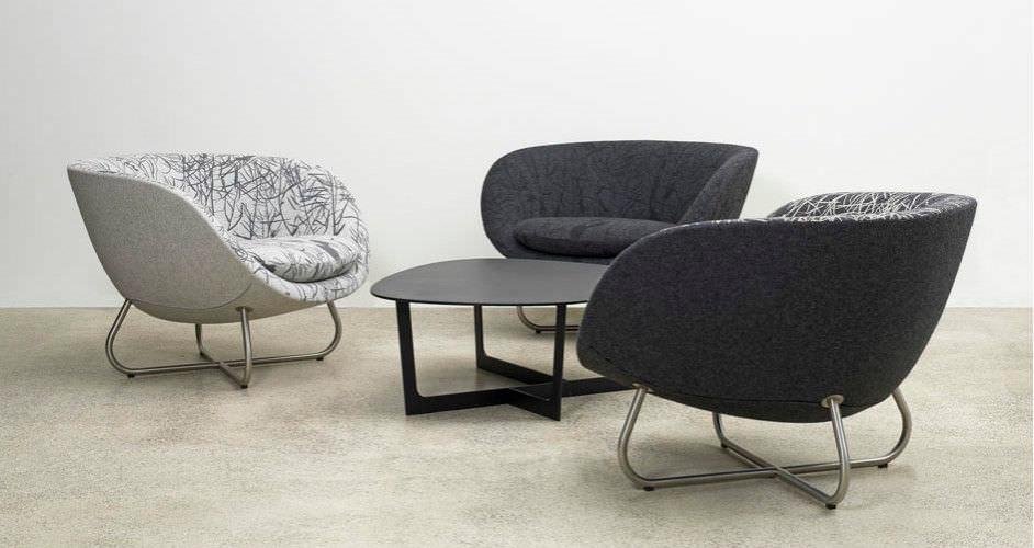 Poltrona de design dinamarquês com encosto envolvente e base de madeira