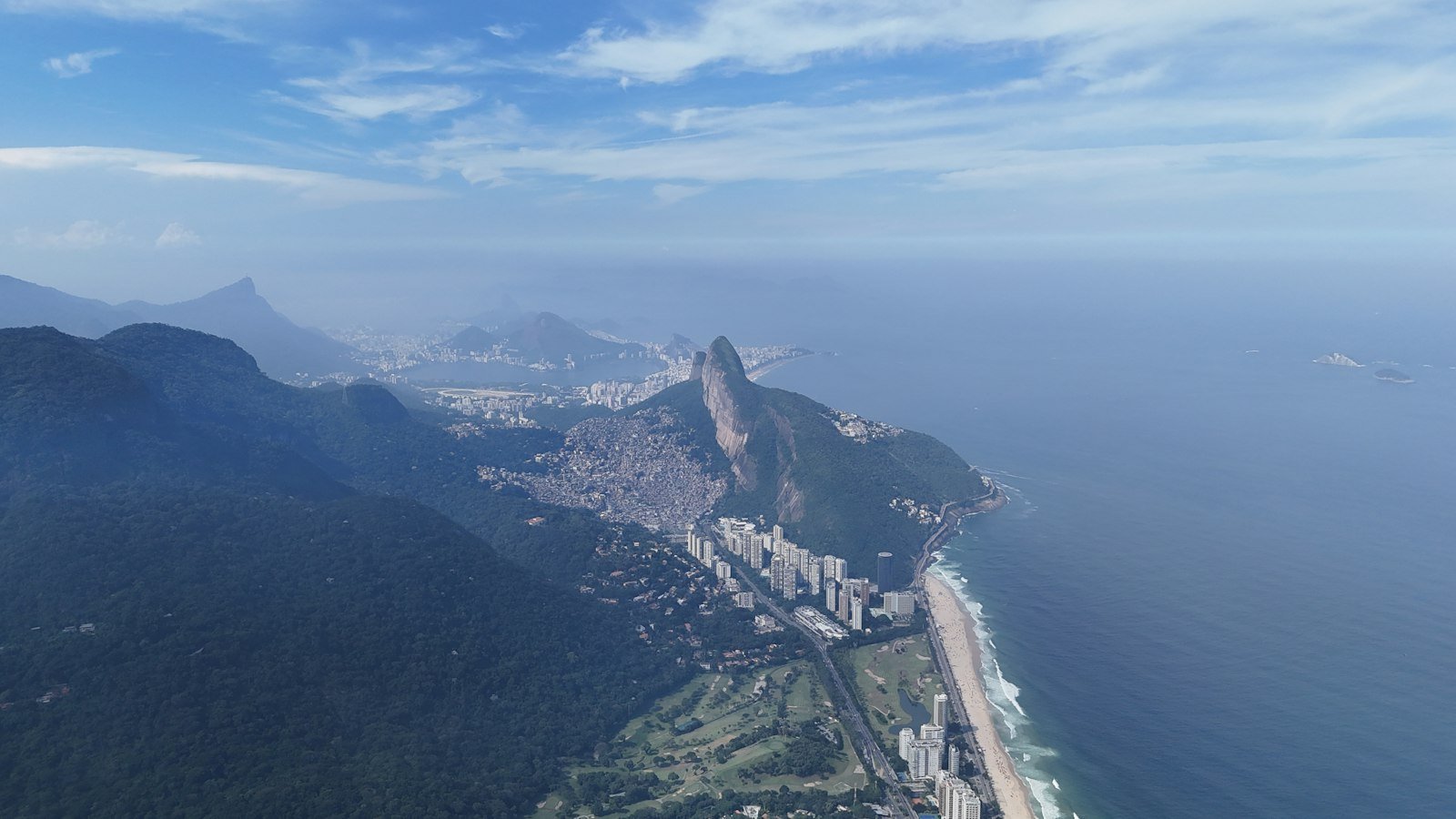 Vista aérea do Rio de Janeiro com montanhas, prédios e praia