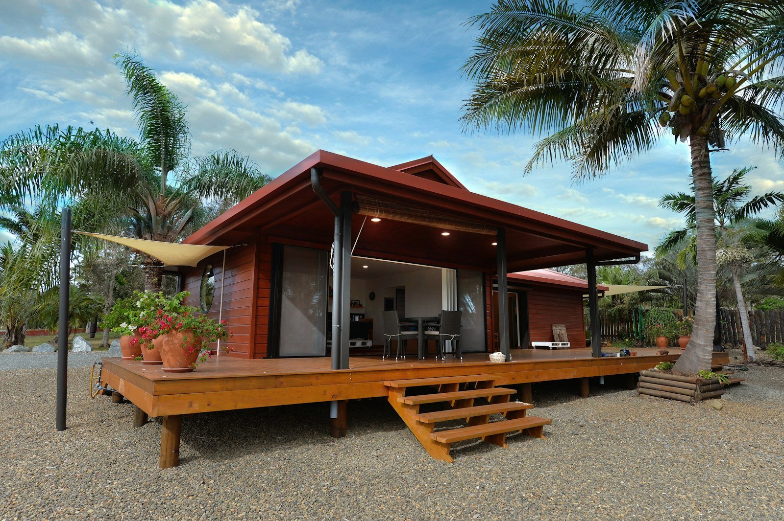 Casa tropical de madeira com deck e palmeiras