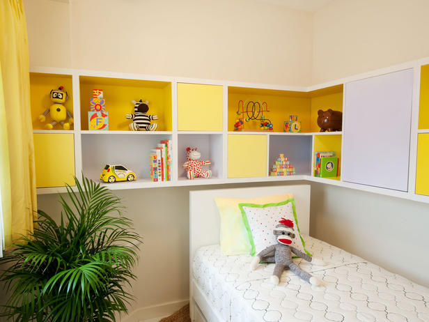 Quarto infantil branco e amarelo com gabinete colorido para brinquedos