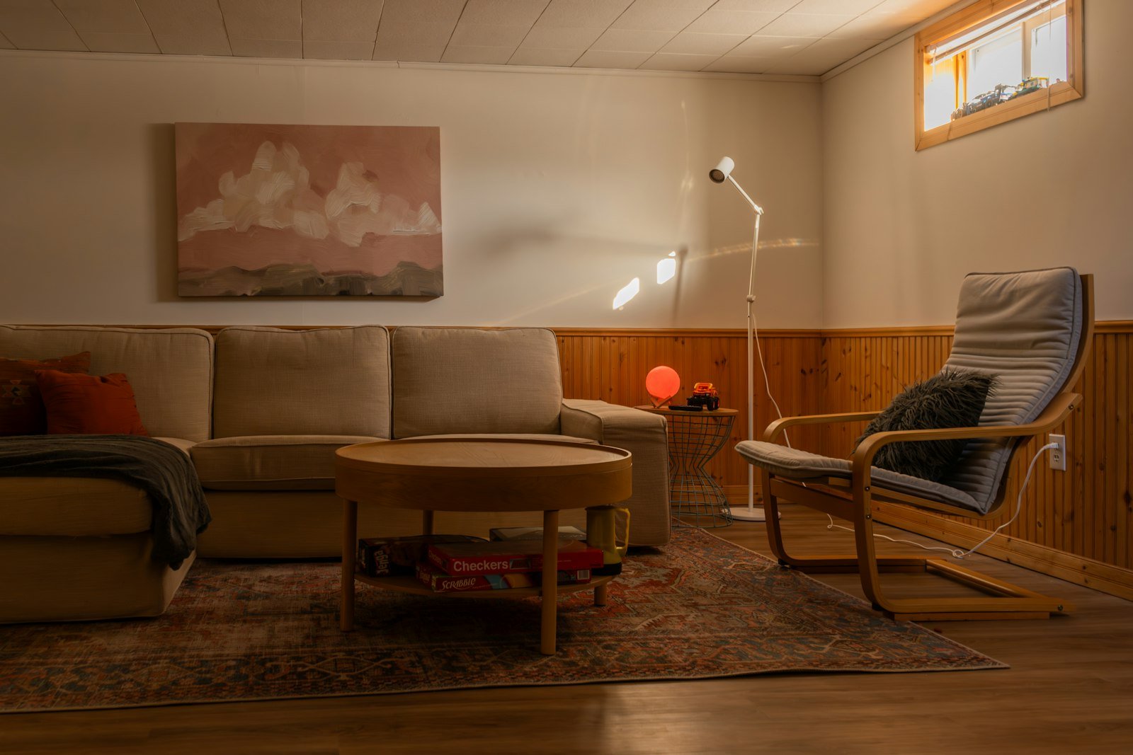 Sala aconchegante com sofá, poltrona e luz quente de luminária