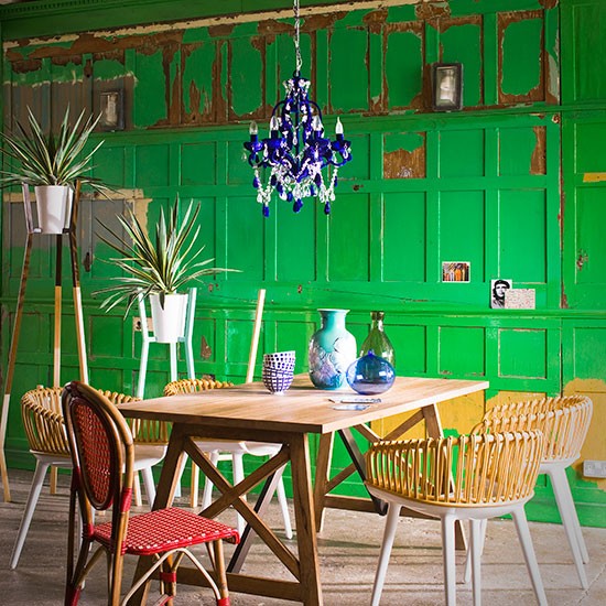 Sala de jantar verde com cadeiras de vime