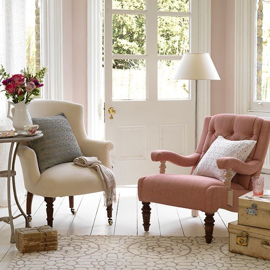 Sala pequena com duas poltronas de estilo vintage e mesa lateral de tampo de mármore