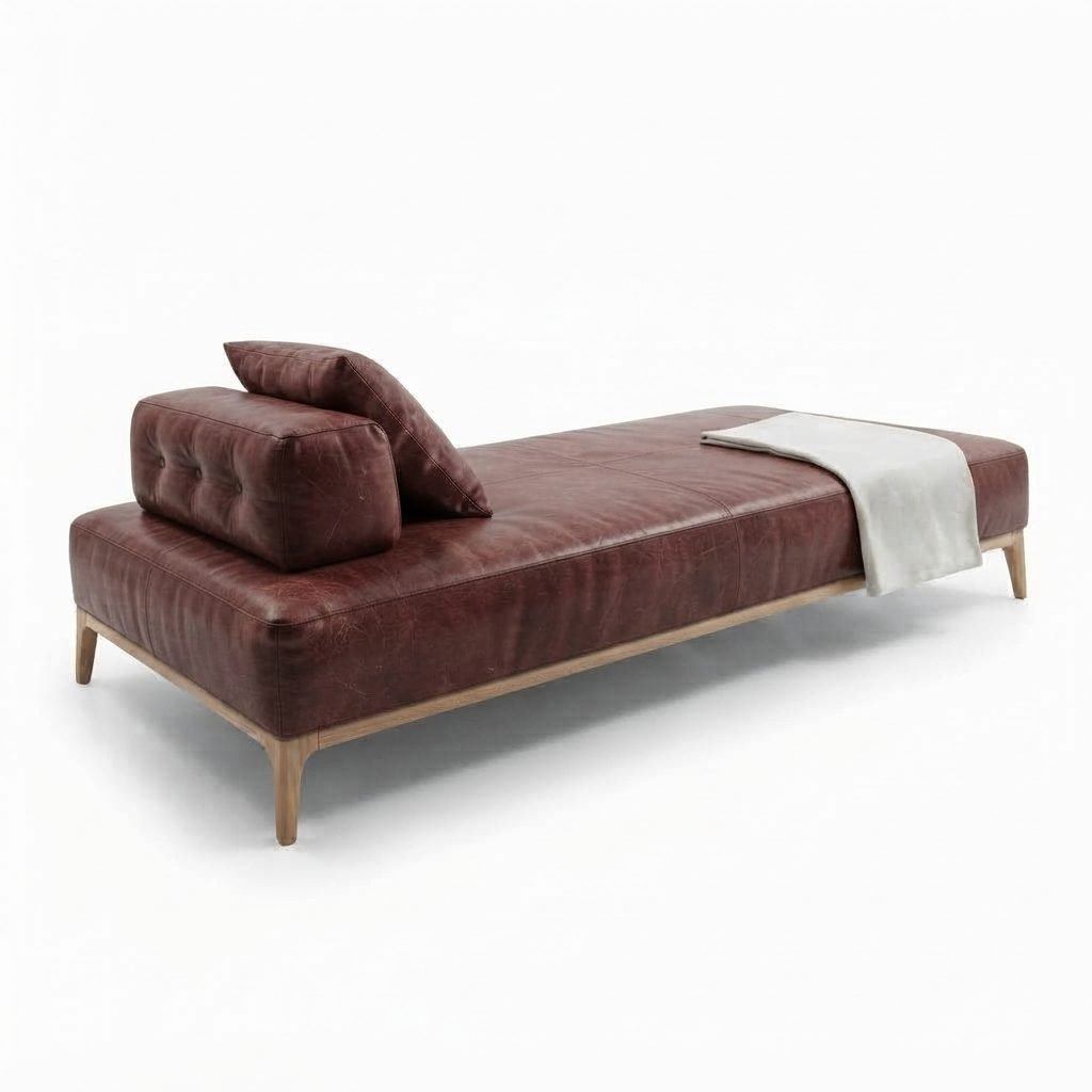 Chaise CH 402 em couro bordô com encosto estofado, almofada solta, manta dobrada e pés de madeira clara torneados.