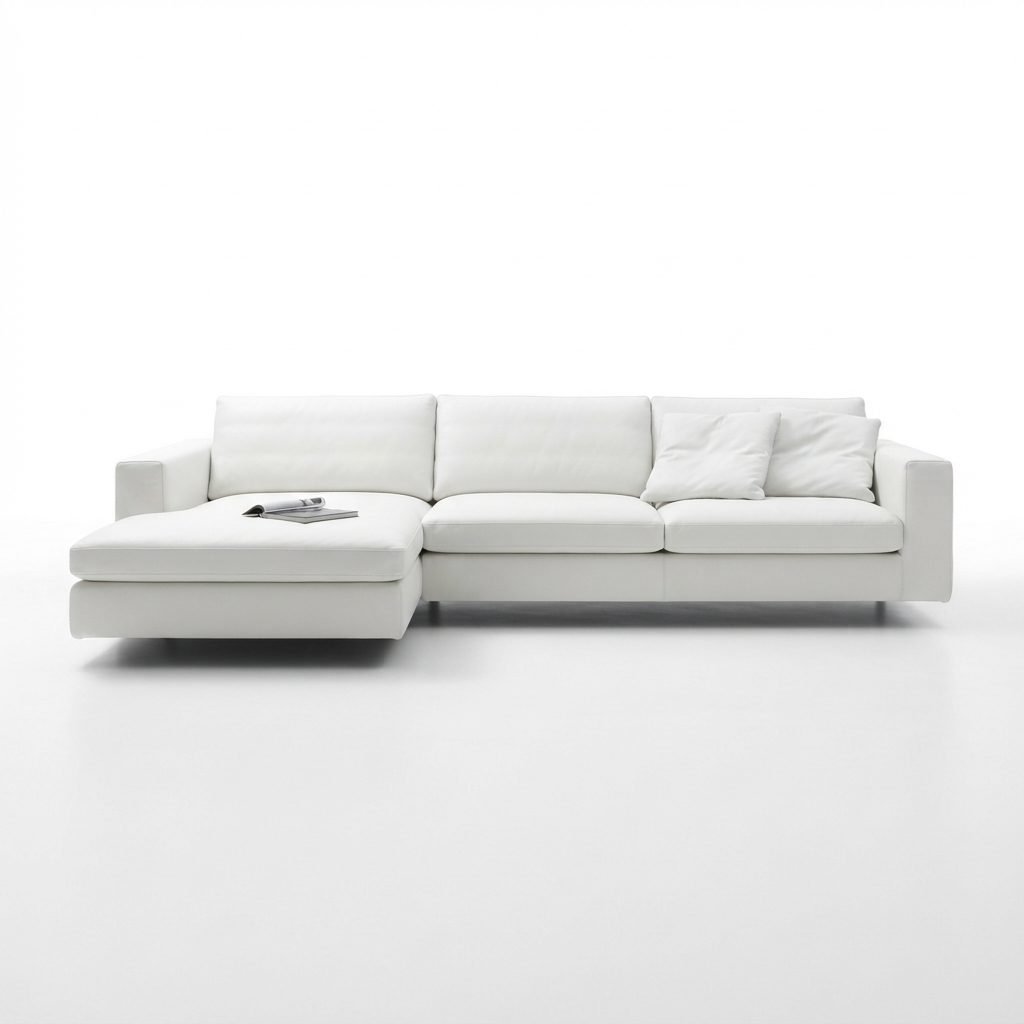 Estofado PL 1089 com chaise em couro branco, almofadas decorativas, pés de metal, fotografado de frente em fundo branco.