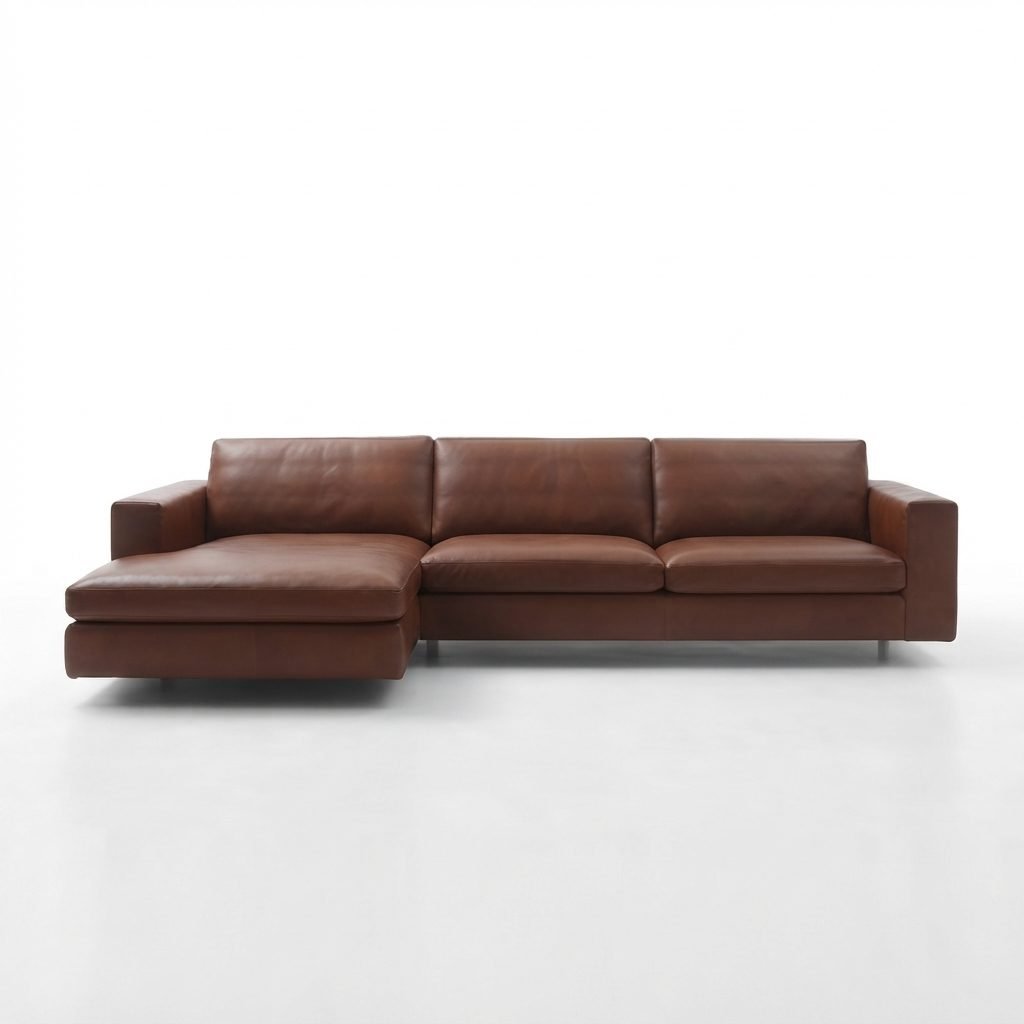 Estofado PL 1089 com chaise em couro caramelo, pés de metal, fotografado de frente em fundo branco.